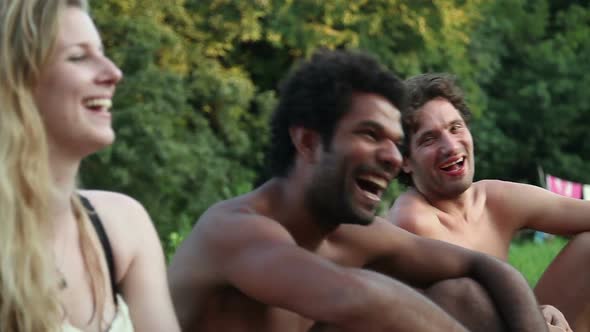 Four friends laughing while sitting in nature