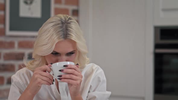 Portrait of Satisfied Woman Drinking Tea on Kitchen