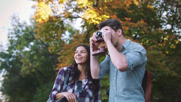 Young Mixed Race Tourist Couple Taking Pictures on Vintage Camera While Walking Through the City