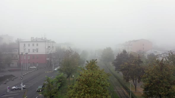 Foggy City Street with Silhouettes of Residential Buildings