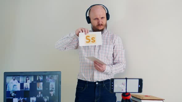 A Bald Man with a Beard Conducts Training Online the Study of Alphabet Uses Flashcards with Letters