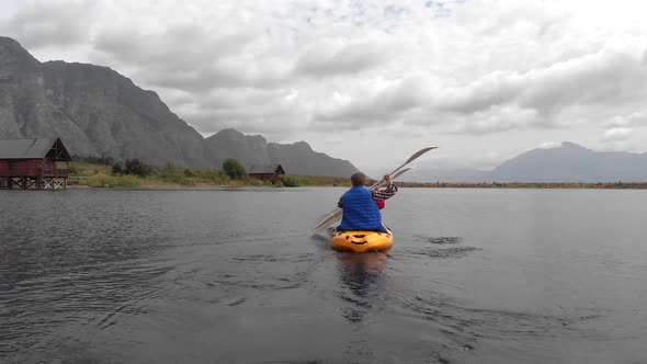 Animation of Caucasian people grumbling in a yellow canoe, montains and white clouds