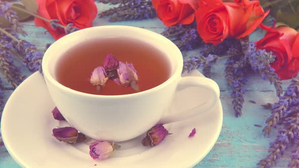 Provencal style composition: tea with fragrant rose buds, fresh rose flowers and lavender