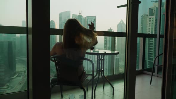 A Girl Sits on the Balcony