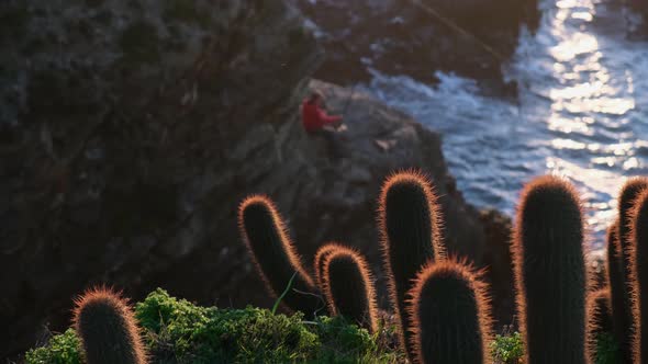  change of focus, man fishing with beautiful sunset light in the middle of the cliff, pichilemu,