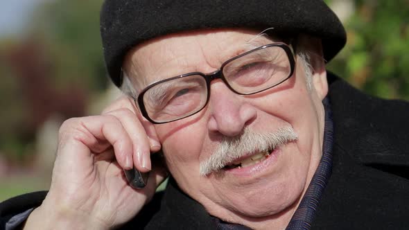 Senior man smiling while relaxing in the park