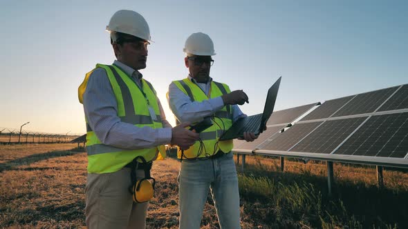 Male Inspectors Are Checking Voltage Level of Solar Panels