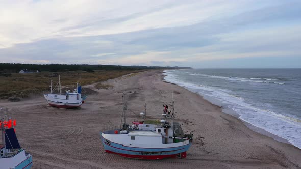 Aerial Over Fishing Boats Standing Ashore on a Sandy Beach on an Overcast Day