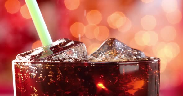 Cola and Drink Tube with Ice and Bubbles in Glass on a Blurry Light Blurry Background