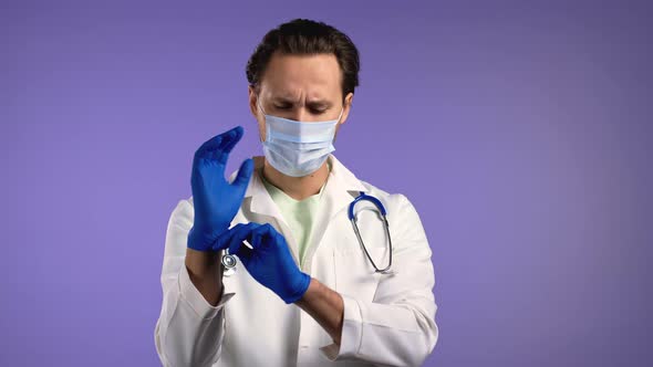 Young Doctor Putting on Latex Gloves and Preparing for Work Operation