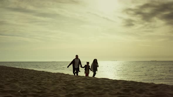 Young Family Running Sea Shoreline