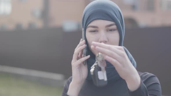 Portrait of Independent Smiling Young Muslim Woman Talking Bey Phone and Holding Car Keys Wearing