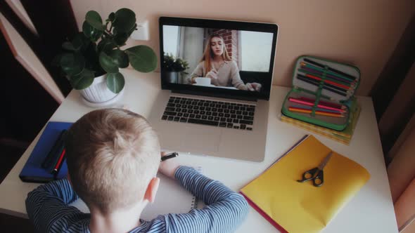 Boy Preschooler Making Online Homework with Female Teacher By Means of Video Call