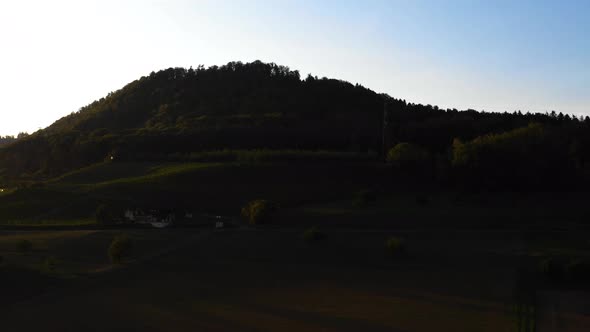 beautiful sunset over grasshill in the countryside of switzerland. aerial drone flight at golden hou