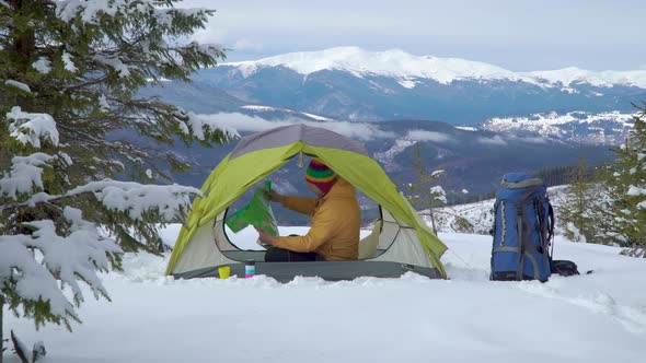 Tourist in a Tent in a Winter Forest