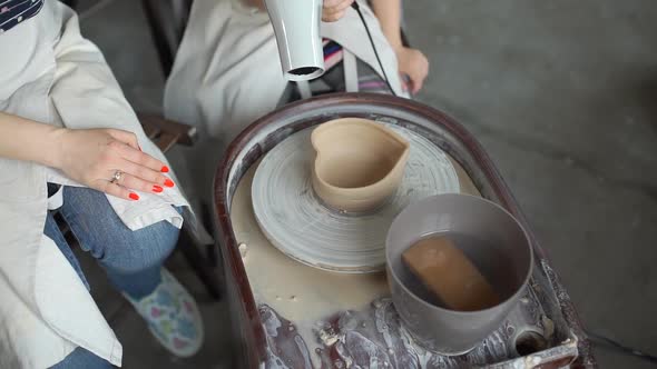 Little Girl Drying Clay Bowl in Pottery Workshop