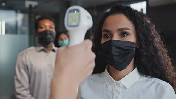 Closeup Young Hispanic Girl Standing Office in Mask Get Health Checked Measure Temperature with