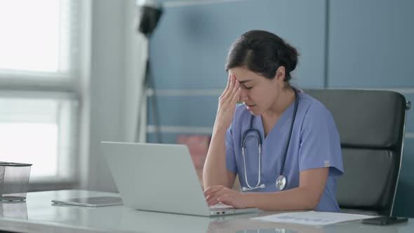 Indian Female Doctor having Headache while Working on Laptop