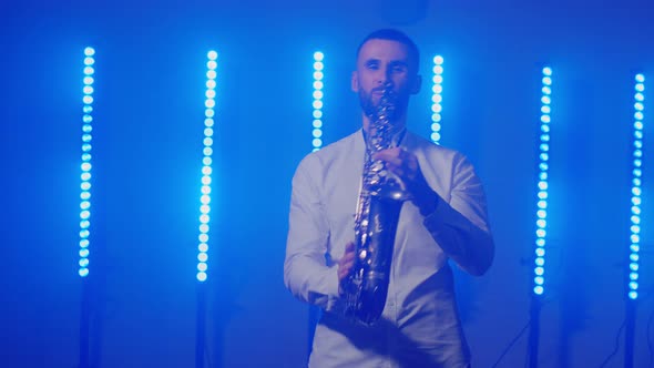 Live Performance of Saxophonist Man with Saxophone Dancing on Concert Musician Stage with Lights