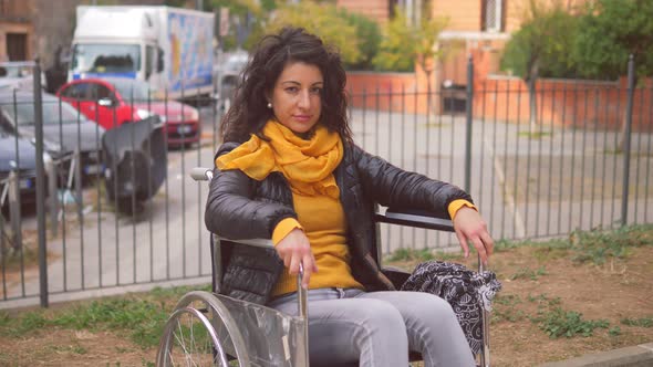 wheelchair user - young woman with paraplegia stares thoughtfully at camera