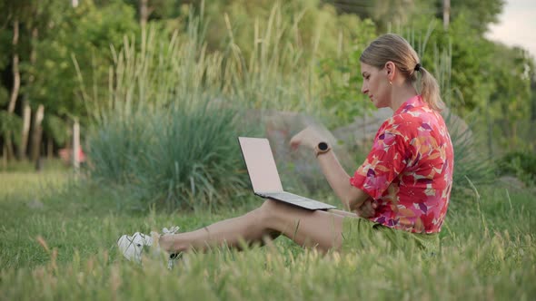 A Middleaged Woman Works Using Her Laptop in a Public Park