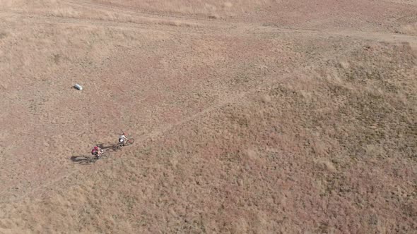 Drone following mountain bikers on a trail in a slow-motion during winter time