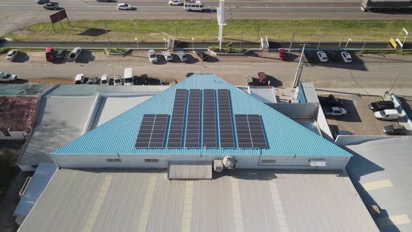 Aerial view of solar panels on a commercial building roof and then revealing the city