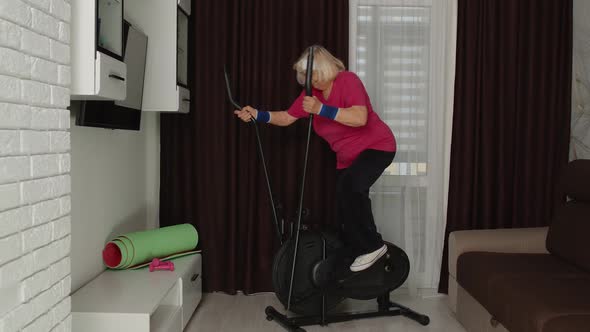 Active Healthy Senior Old Mature Woman in Sportswear Using Orbitrek Training Cardio Workout at Home