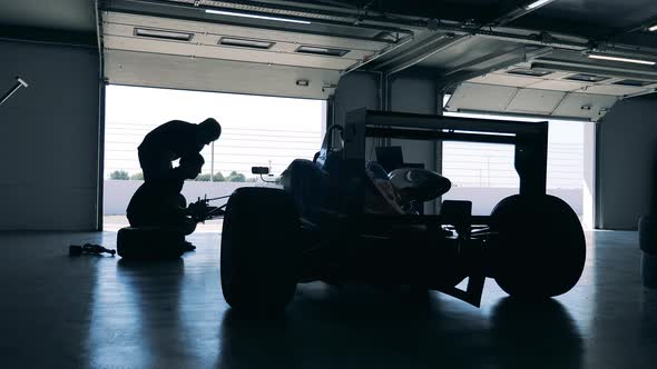 Garage Workers are Fixing a Racing Car