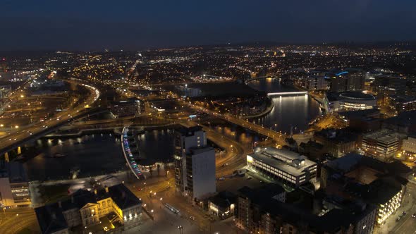 Aerial flyover of Belfast City Centre and Lagan River at night