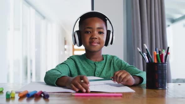 Portrait of african american boy wearing headphones talking looking at the camera