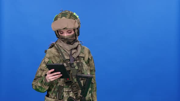 Modern Soldier Female in Camouflage on the Blue Chroma Key Military Engineer Uses a Digital Screen
