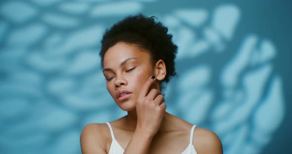 A Young African American Woman Touching the Skin of Her Face with Her Hands