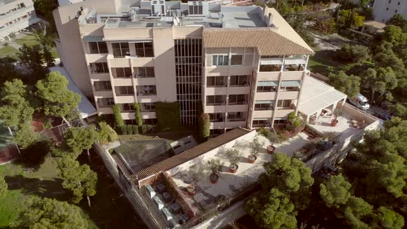 Aerial view of a residential building, surrounded by trees in Greece.