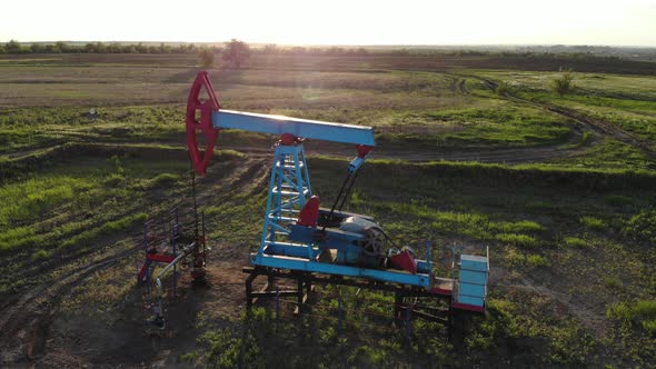 Working Oil Pump From Oil Field at Sunset. The Industrial Equipment.