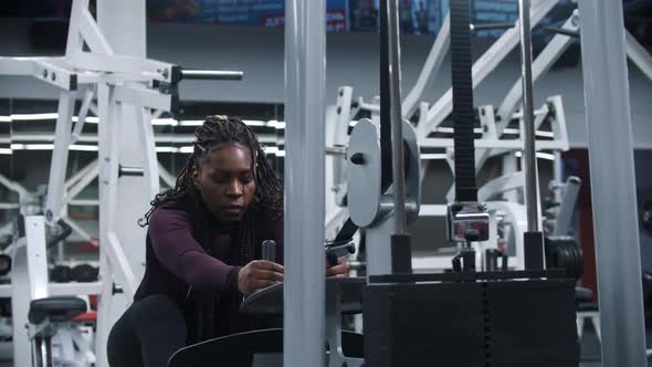 An Africanamerican Woman Working Out in a Gym on a Exercise Equipment