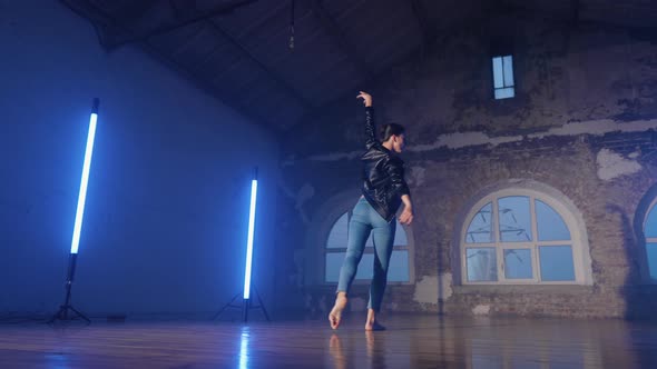 Young Woman in Casual Style  Jeans and Leather Jacket Doing Ballet in Modern Studio