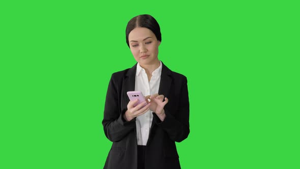 Casual Female in a Suit Texting on Her Phone on a Green Screen Chroma Key