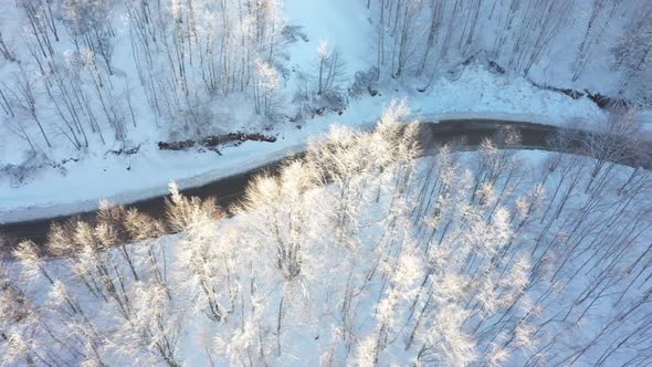 A White Car Driving on a Snowy Road