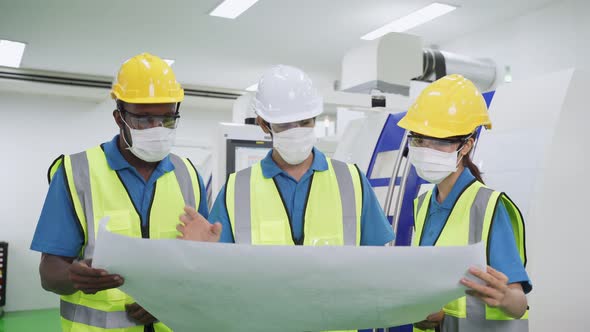 Group of interracial male and female worker people wear protective face mask and look at drawing.