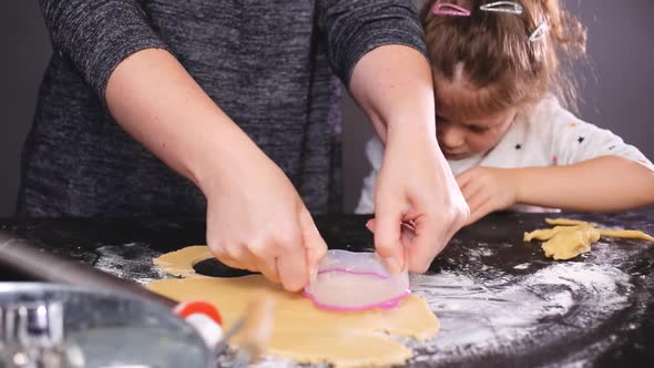 Mother and daughter baking sugar skull cookies for Dia de los Muertos holiday.