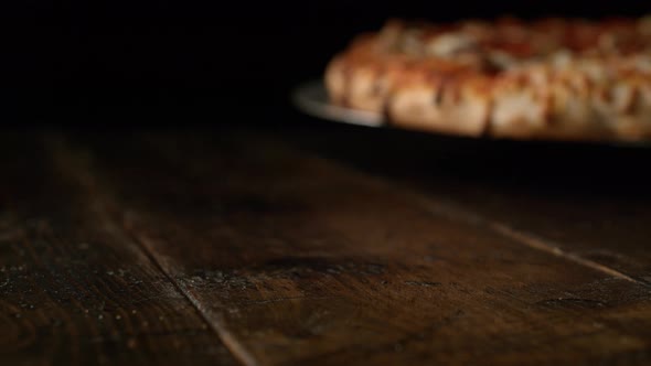 Camera follows a pizza with pepperoni being served. Slow Motion. alt