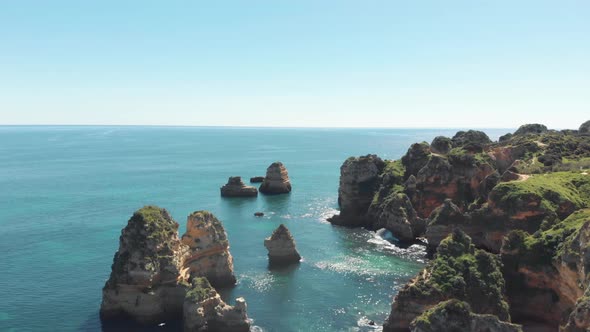 Rocky protuberances rising from the salty Algarvian sea, in Lagos coastline, Portugal