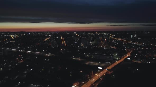 Aerial view of cars in night black big city and sunset on the horizon 19