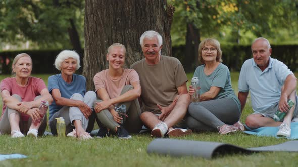 Portrait of Positive Elderly People and Fitness Coach in Park