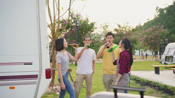 Group of Asian man and woman friends are having holiday party outdoor on camp in evening together.