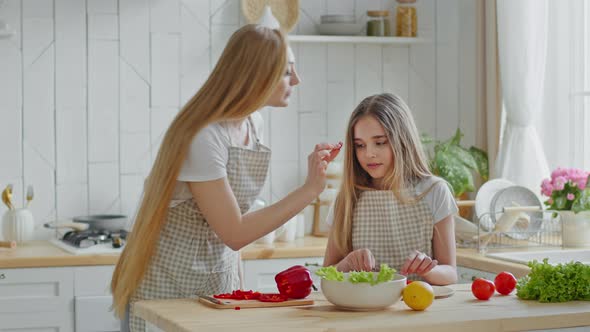 Adult Mother Housewife and Daughter Child Girl Helper Wear Aprons Cook Together in Kitchen Cut