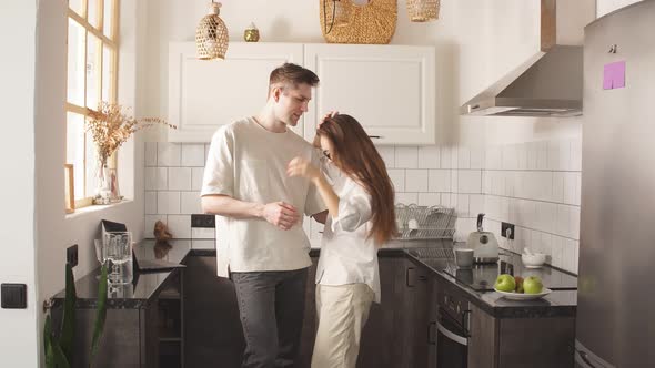 Young Caucasian Married Couple in Love, Dance in Kitchen.