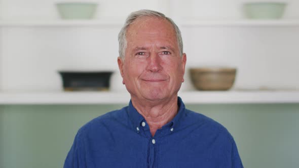 Portrait of happy senior caucasian man at home smiling to camera