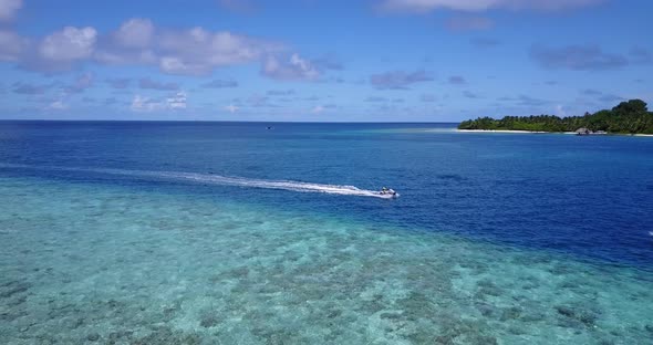 Wide flying abstract view of a paradise sunny white sand beach and aqua turquoise water background 